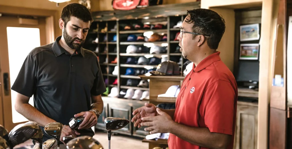 A sales assistant and customer in a golf shop